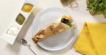a white plate topped with a cut in half and sitting on a table
