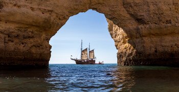 un barco en un cuerpo de agua con una montaña en el fondo