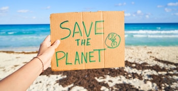 a person holding a sign in front of a beach