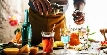 una persona sentada en una mesa con copas de vino