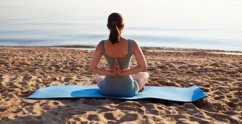 una mujer sentada en una tabla de surf en la playa