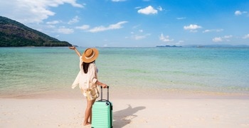 a person with a suitcase on a beach