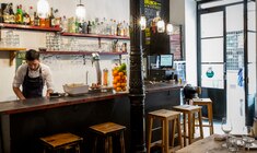 una persona sentada en una mesa frente a una tienda