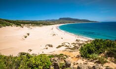 una playa de arena junto a un cuerpo de agua