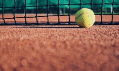 a person swinging a racket at a ball