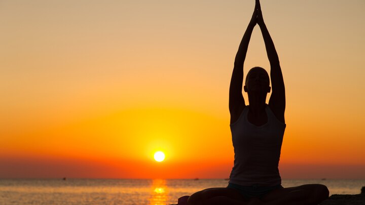 a person standing in front of a sunset
