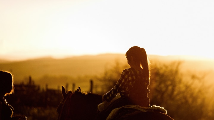 a person standing in front of a sunset