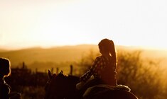 a person standing in front of a sunset