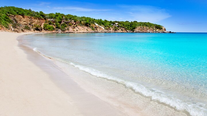 a sandy beach next to a body of water