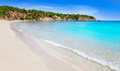 a sandy beach next to a body of water