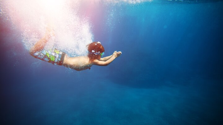eine Person, die in einem Gewässer schwimmt