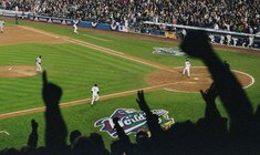 eine Gruppe von Personen, die um ein Baseballfeld sitzen